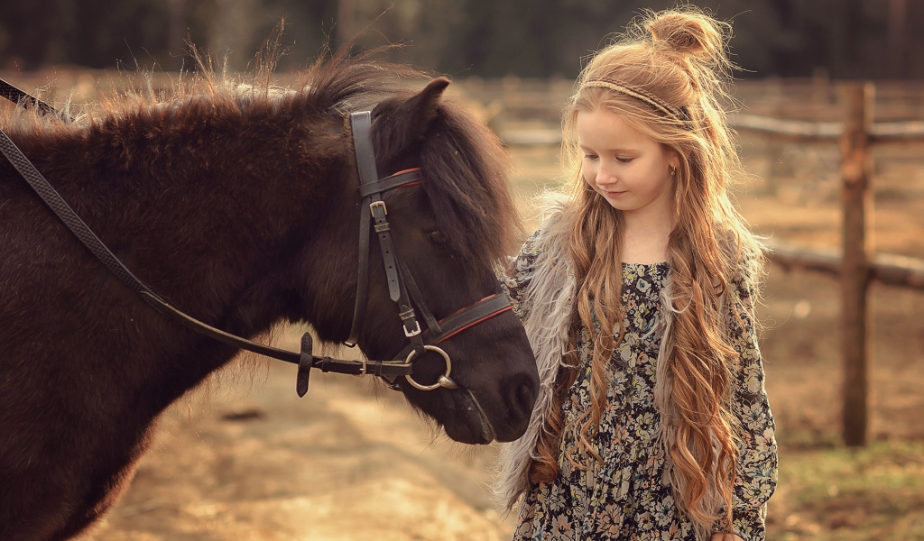 Маленькая девочка с пони на ферме