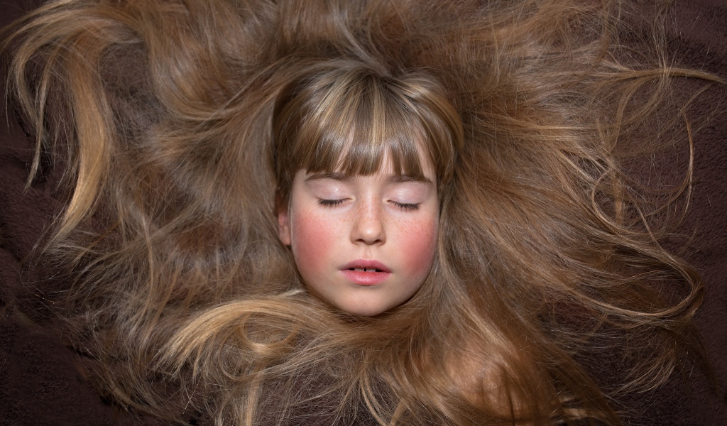 Маленькая спящая девочка с длинными волосами