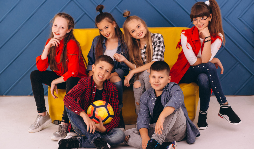 Много модных школьников сидят на диване