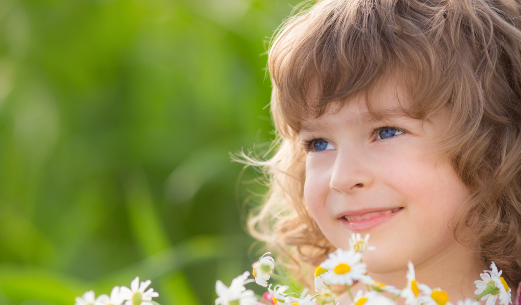 Улыбающаяся девочка с букетом ромашек 