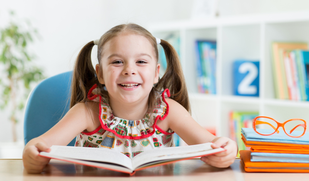Улыбающаяся маленькая девочка с книгой 