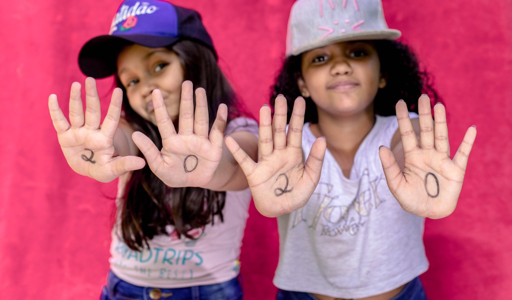 Две маленькие девочка с цифрами на ладонях 