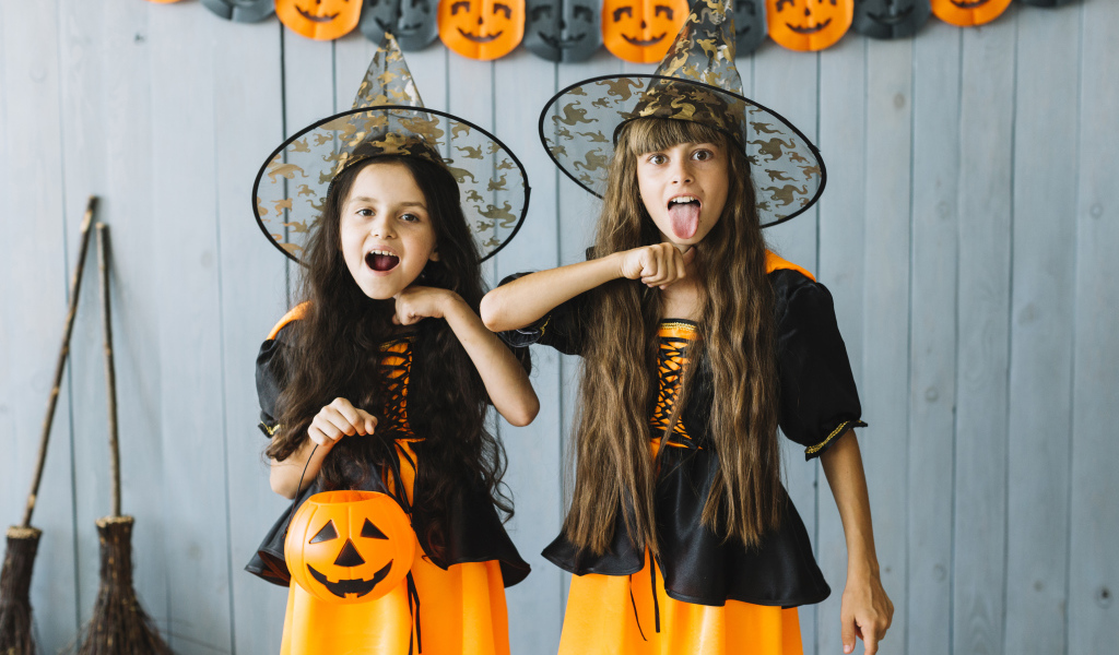 Две маленькие девочки в костюмах ведьмы на Хэллоуин