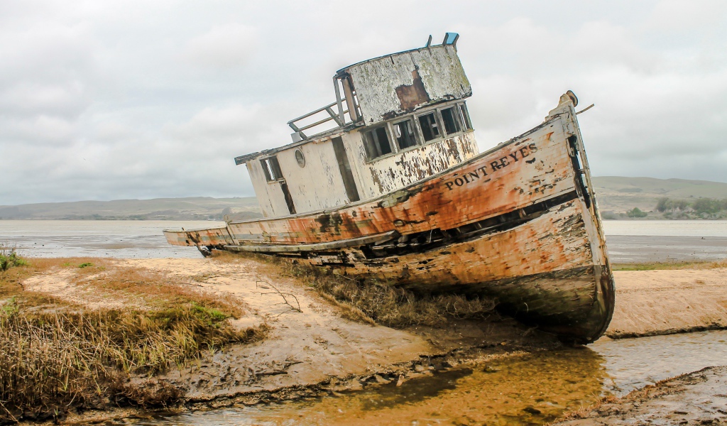 Старая заброшенный рыбацкий баркас на берегу 