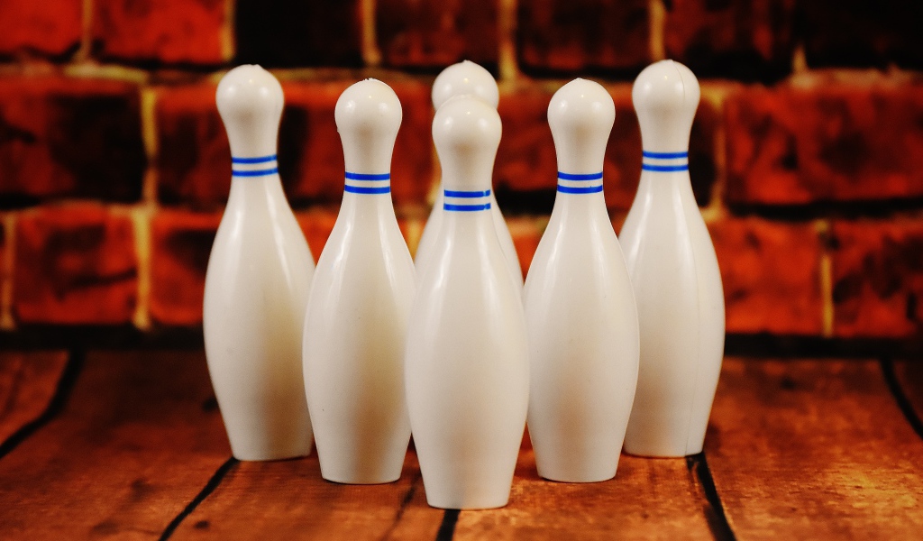 Белые кегли стоят у стены 