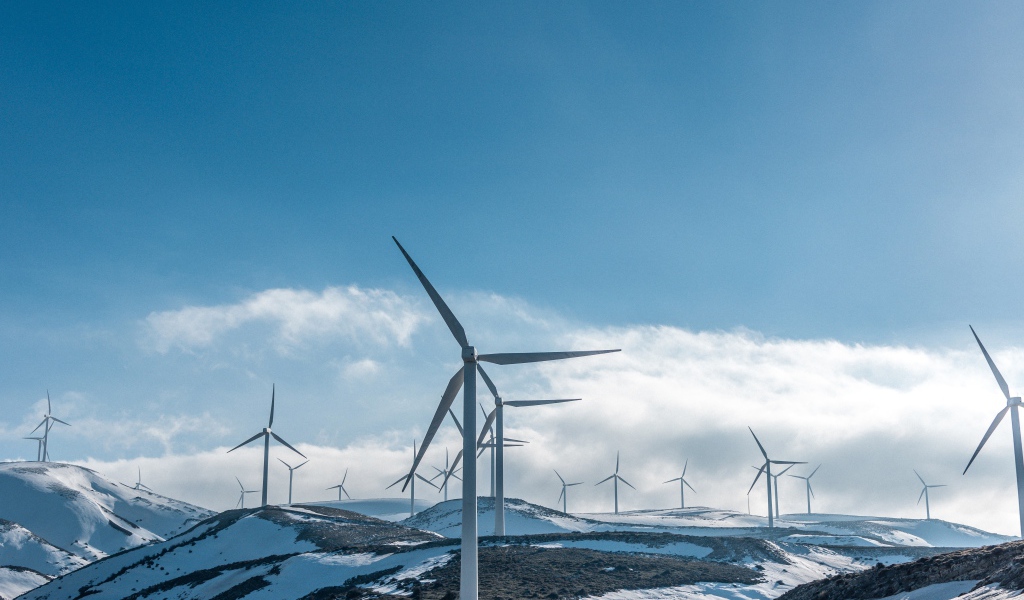 Large wind turbines on snowy slopes