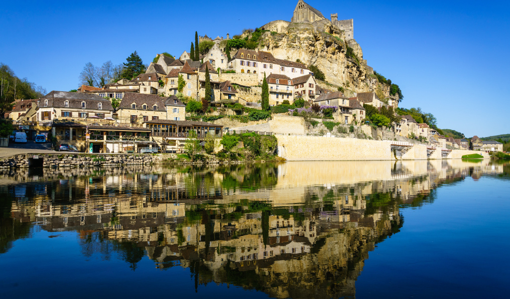 Дома на скале у воды под голубым небом, Франция 