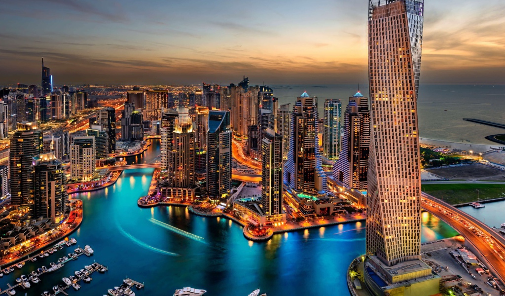 Высокие небоскребы ночного города Дубай у воды 