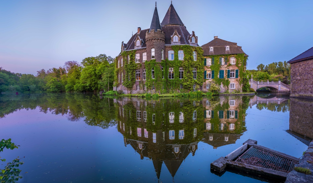 Старинный покрытый зеленью замок Линнеп отражается в воде