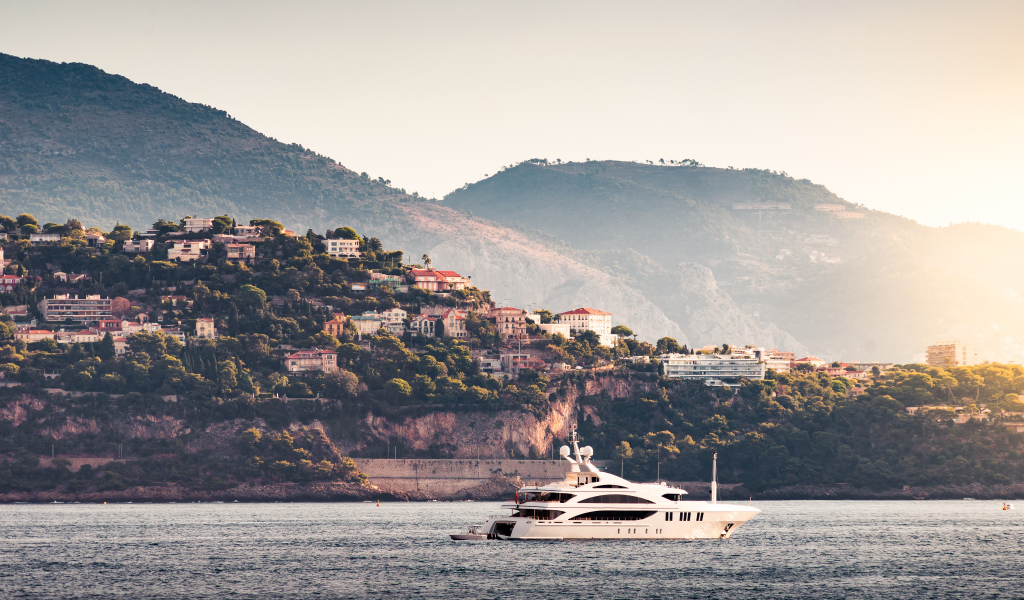 Белая яхта в море на фоне города Монте Карло, Монако
