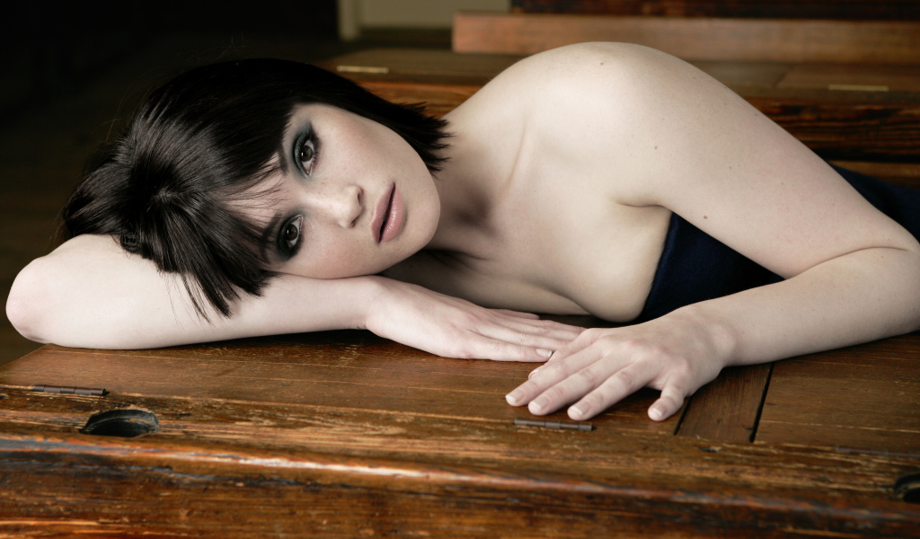 Актриса Джемма Артертон лежит на деревянном столе