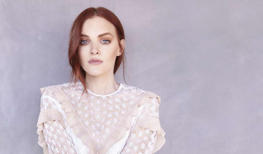 Актриса Мадлен Брюэр в белом платье на фоне стены