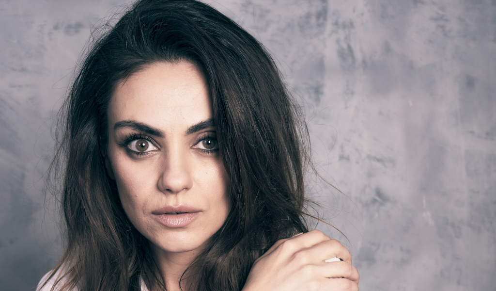 Американская актриса Мила Кунис на сером фоне