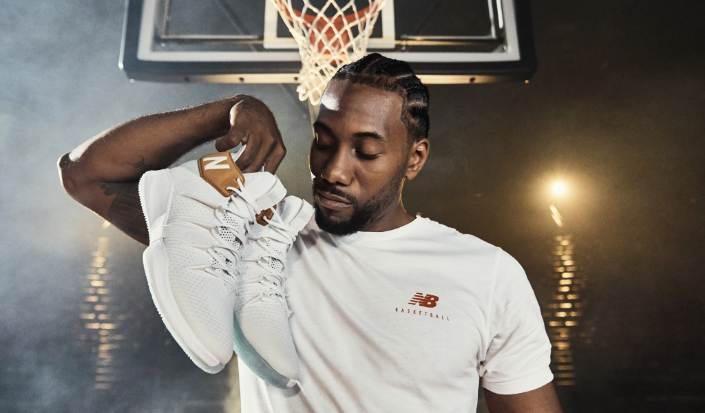 Американский баскетболист Кавай Леонард с кроссовками в руке