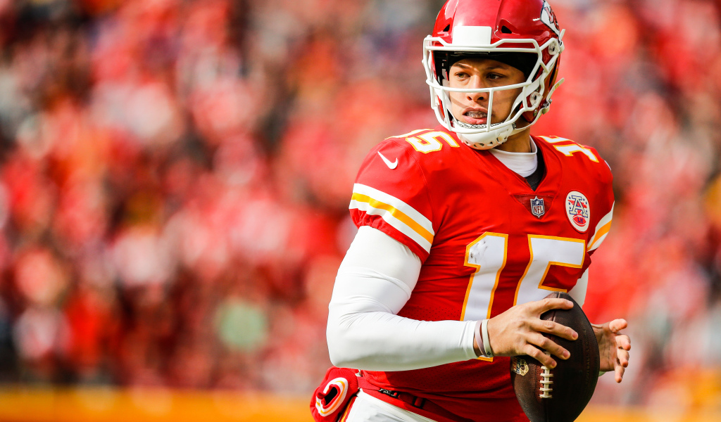 Игрок в американский футбол Патрик Махоумс на поле с мячом