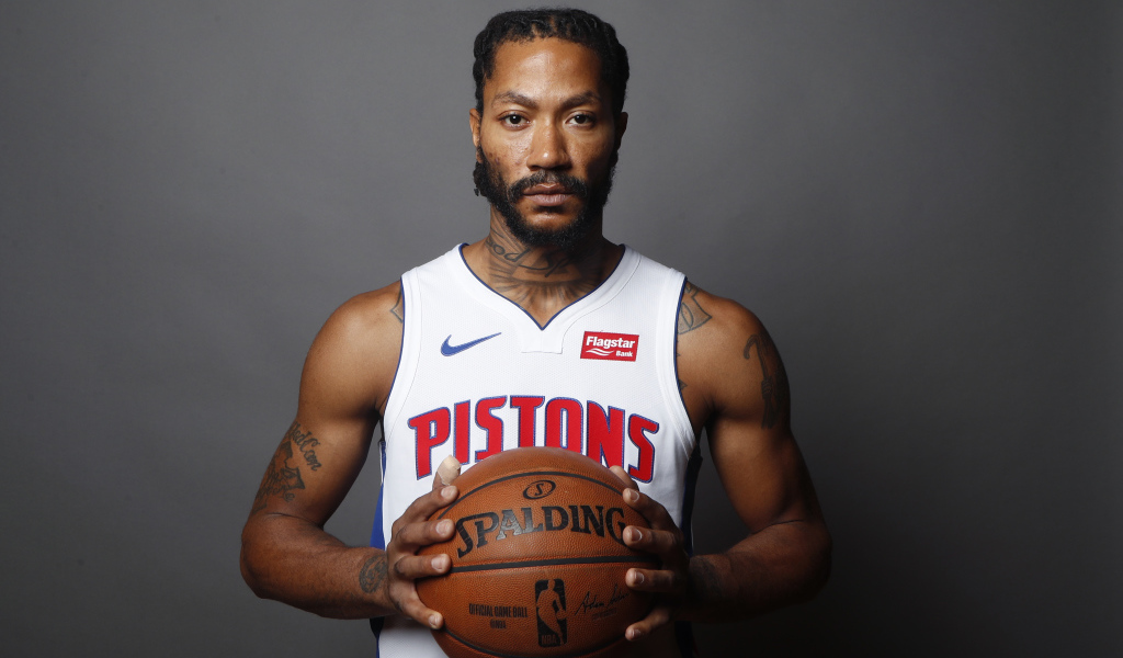 Basketball player Derrick Rose in the ball in his hands on a gray background