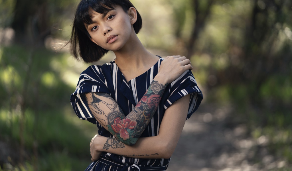 Красивая девушка азиатка с татуировками на руках 