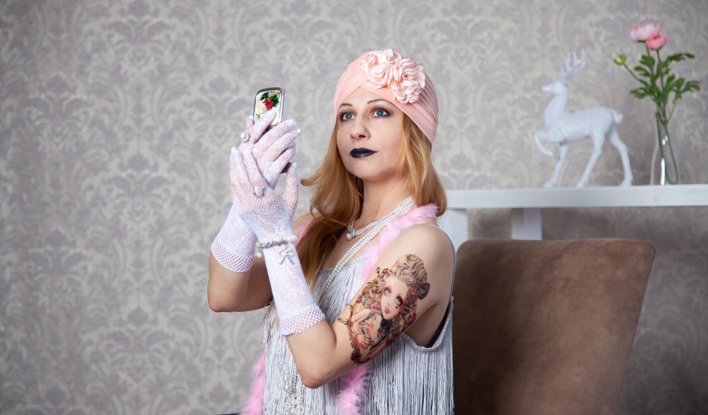 Красивая ретро девушка с татуировкой на руке