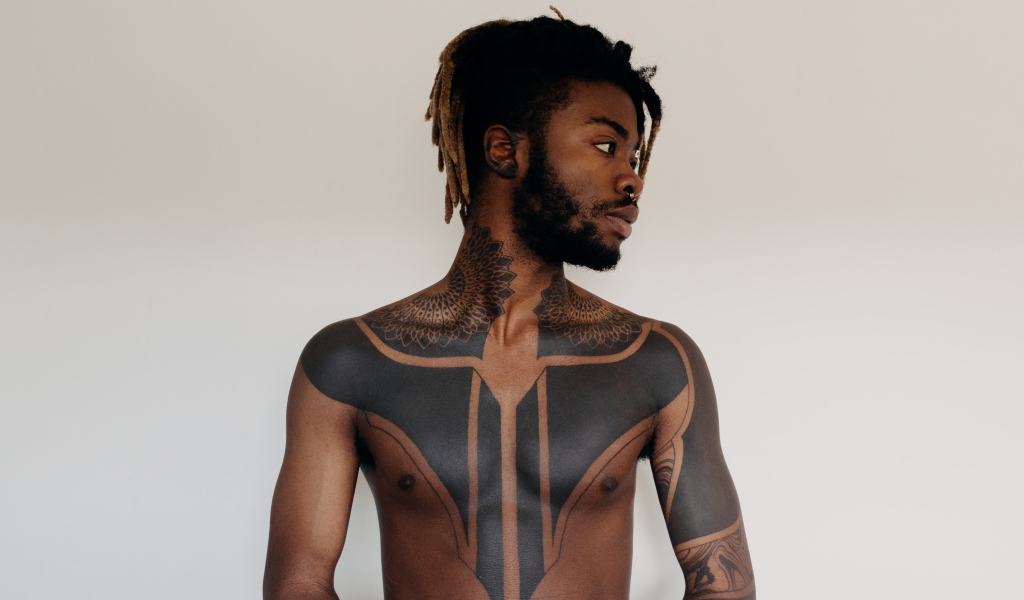 Темнокожий мужчина с татуировками на теле