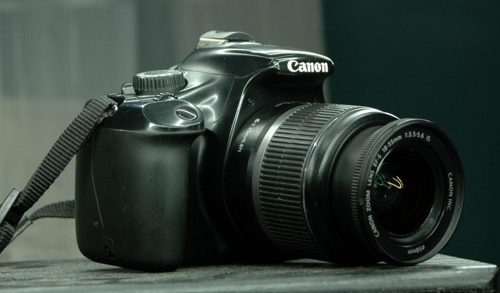 Фотоаппарат Canon 1100D лежит на столе