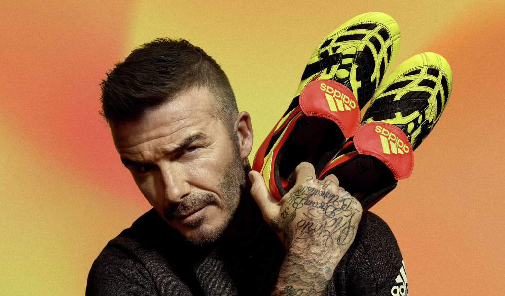 Футболист Дэвид Бекхэм с кедами Адидас в руке