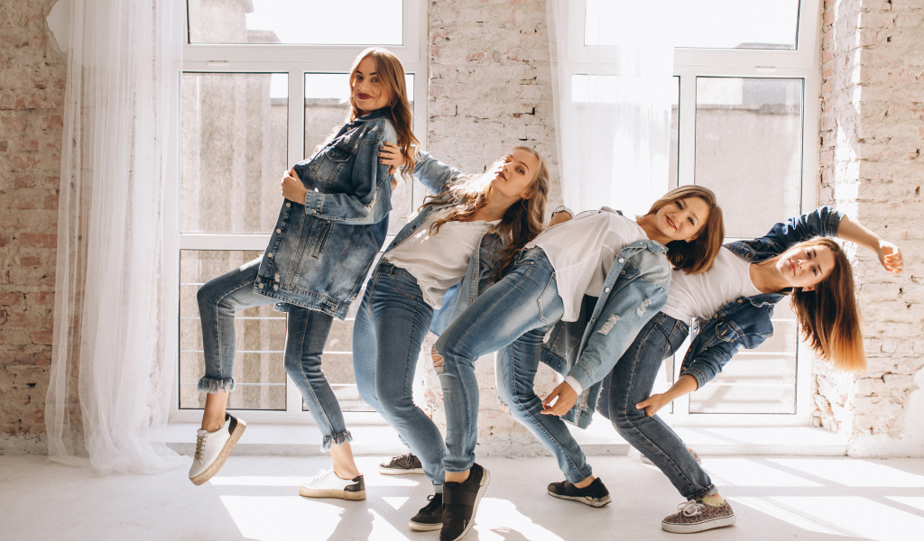 Четыре девушки в джинсовых костюмах занимаются танцами