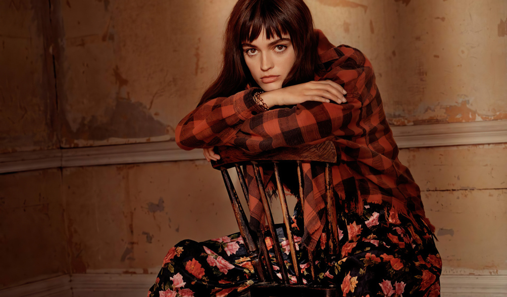 Французская актриса Эмма Макки сидит на стуле