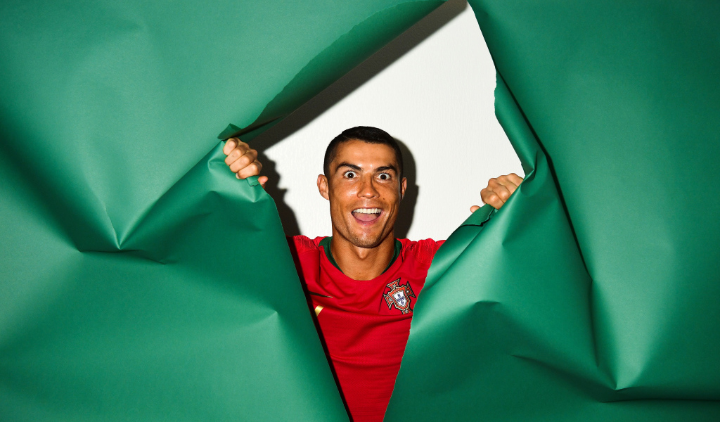 Смешное лицо футболиста Криштиану Роналду на зеленом фоне
