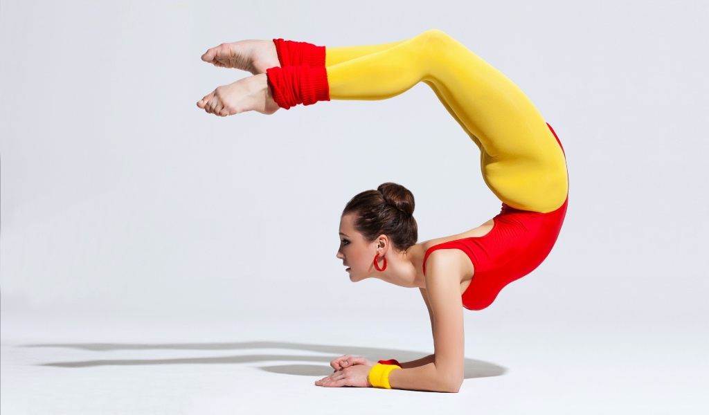 Девушка гимнастка делает стойку 