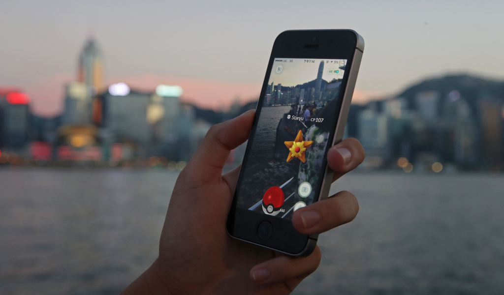 Парень ловит покемонов на смартфоне 