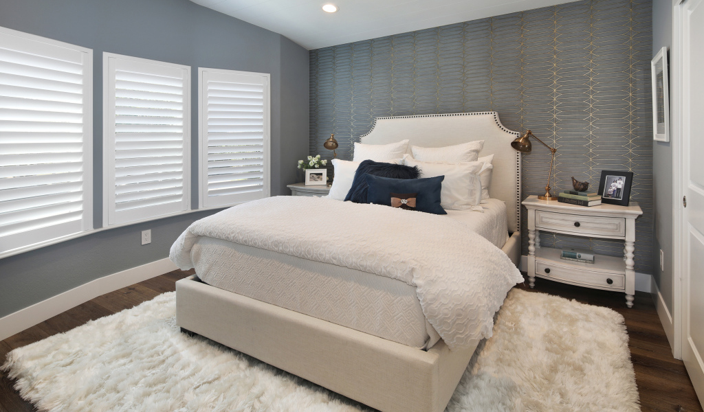 Высокая кровать в спальной комнате в серых тонах