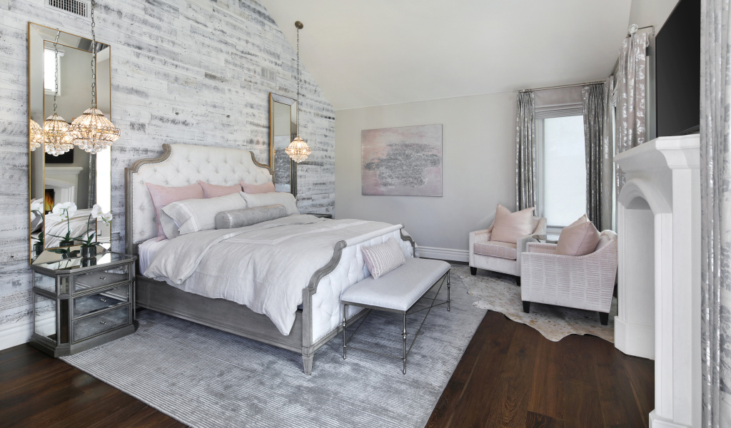 Большая кровать в светлой спальне  с камином