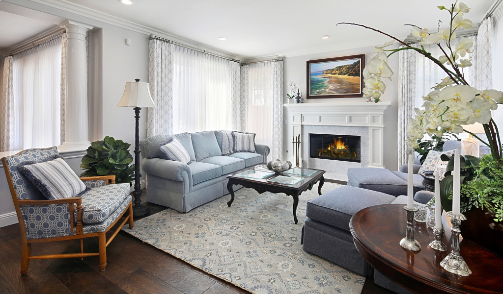 Большая гостиная комната с камином и живыми цветами