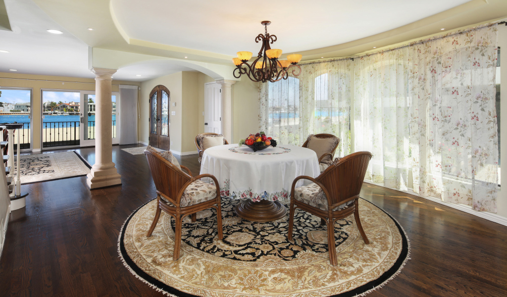 Большая гостиная комната с большими окнами и столом 