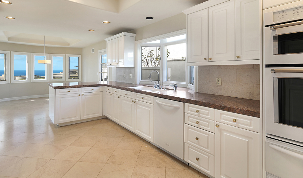 Большая белая кухня с окнами 