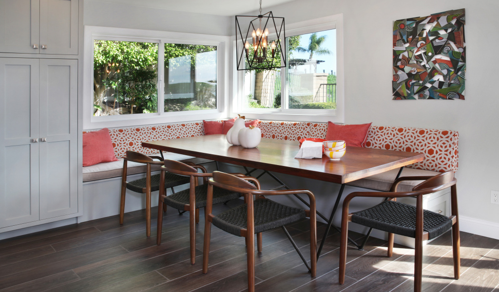 Большой деревянный стол и диван у окна в гостиной 