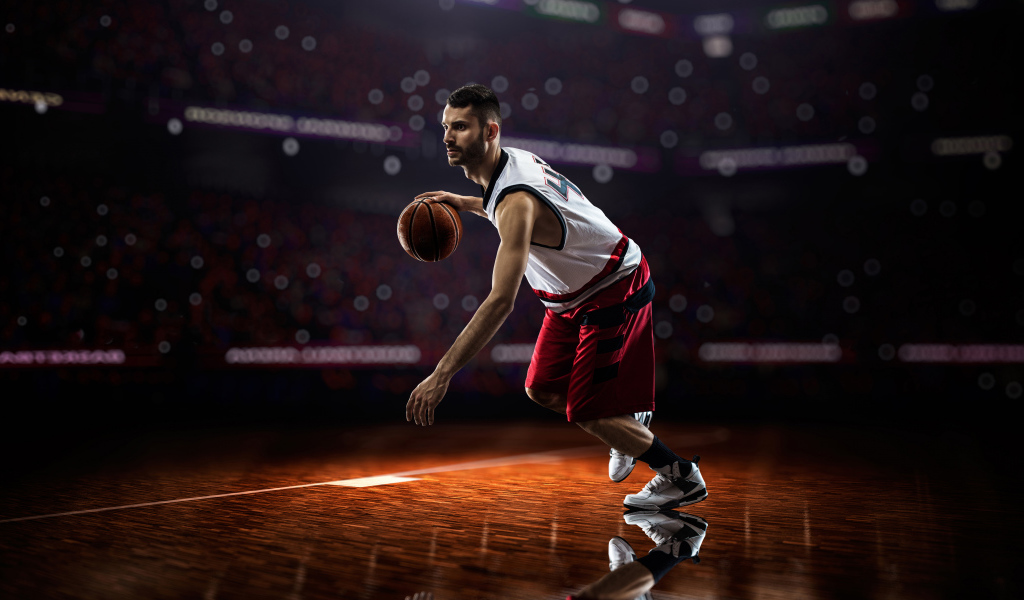 Мужчина баскетболист отбивает мяч на поле 