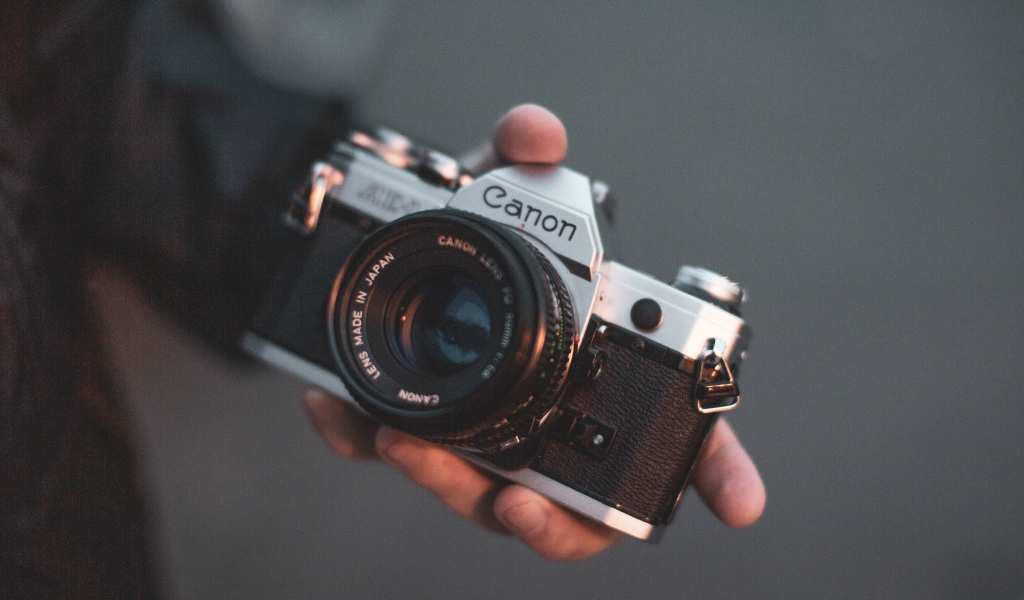 Старый фотоаппарат  Canon в руке 