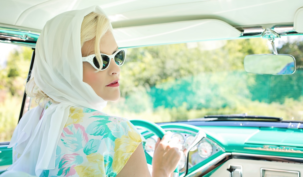 Ретро девушка в очках в старом автомобиле