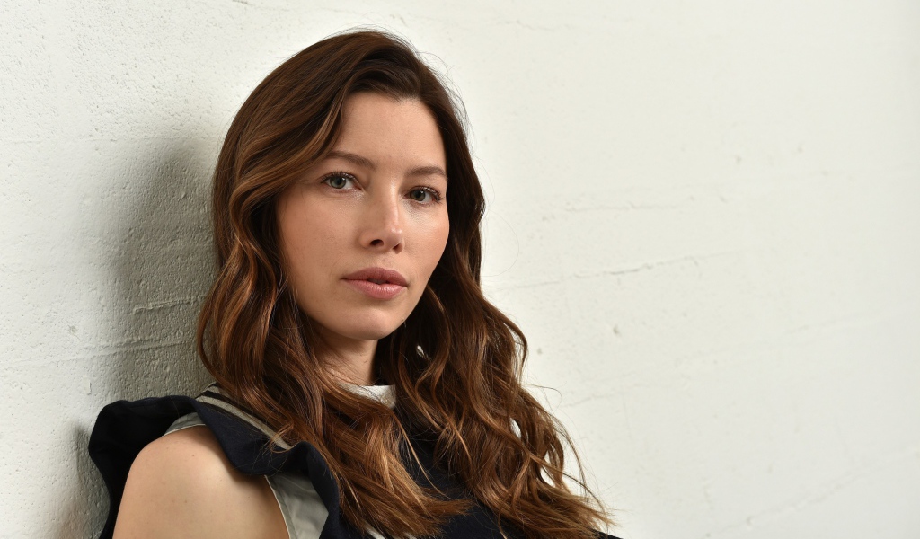 Грустная актриса Джессика Бил сидит у стены