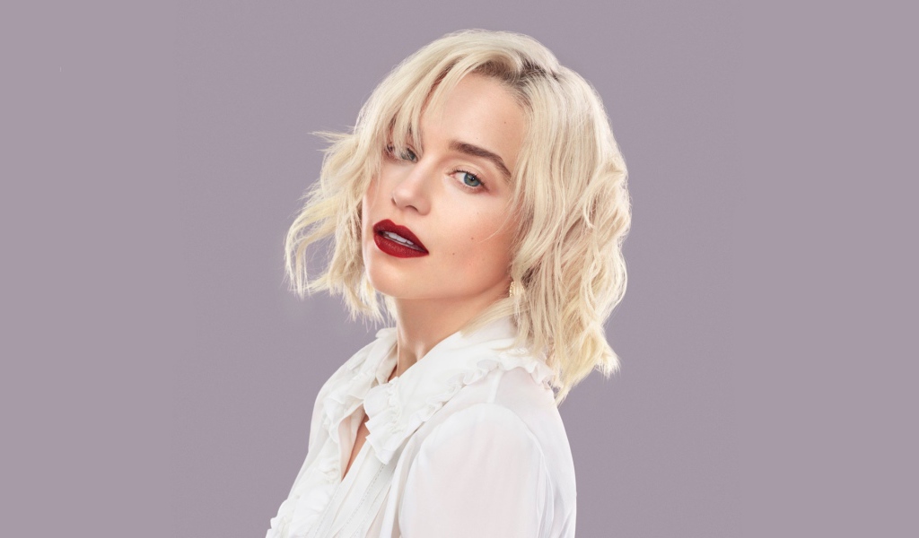 Эффектная блондинка, актриса Эмилия Кларк на сером фоне