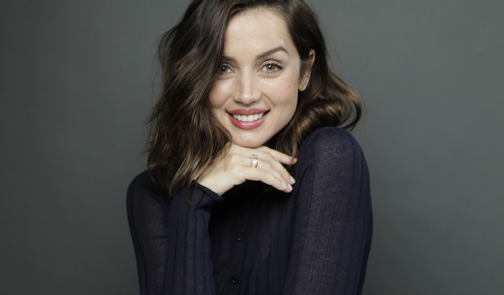 Улыбающаяся актриса Ана де Армас на сером фоне