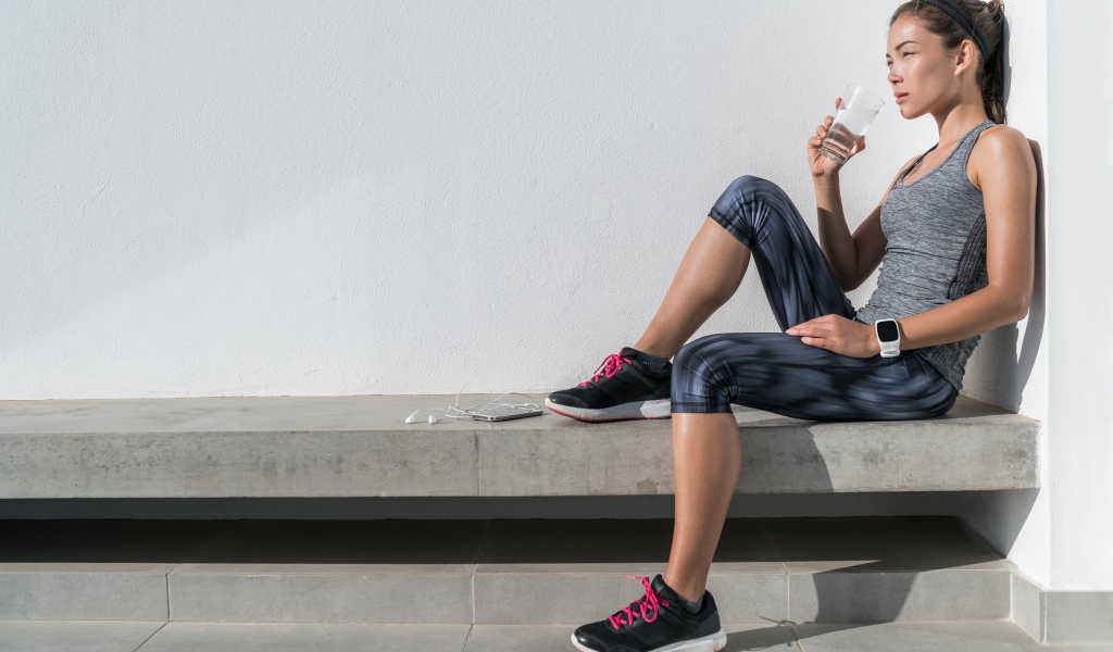 Спортивная девушка в костюме отдыхает после тренировки