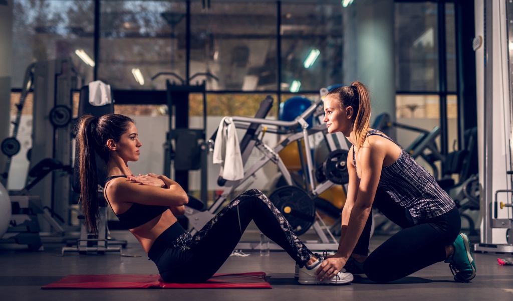 Две девушки занимаются в спортзале 