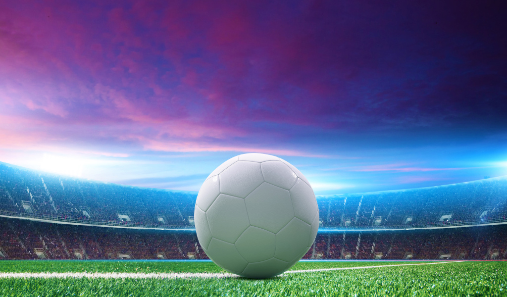Белый футбольный мяч на зеленой траве на стадионе 