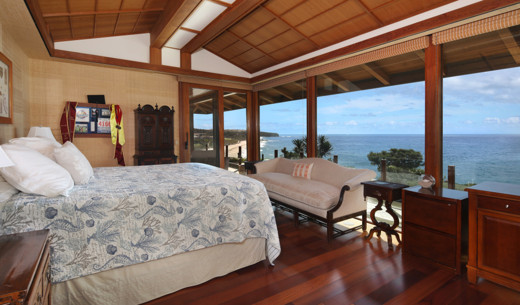 Деревянная спальня с большой кроватью и видом на море 