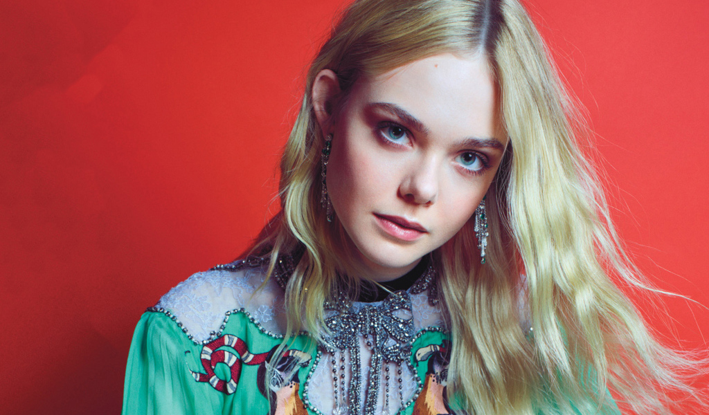 Молодая  блондинка, актриса Эль Фэннинг на красном фоне