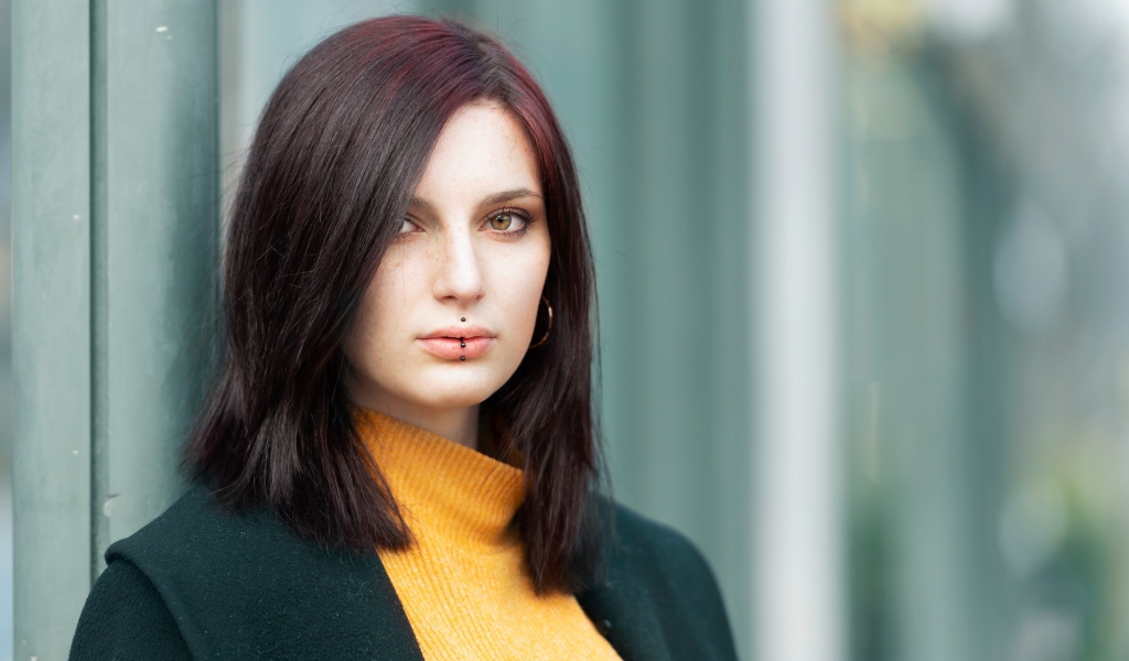 Молодая девушка с черным пирсингом на губах