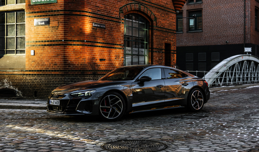Черный автомобиль Audi RS E-Tron GT 2021 года у здания