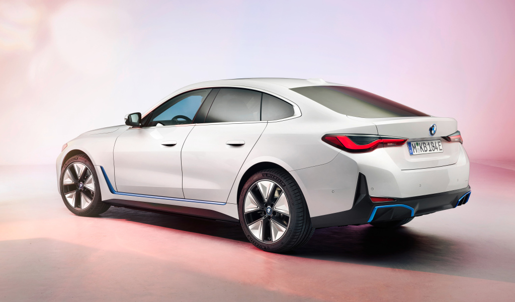 Белый автомобиль BMW I4 2021 года на розовом фоне